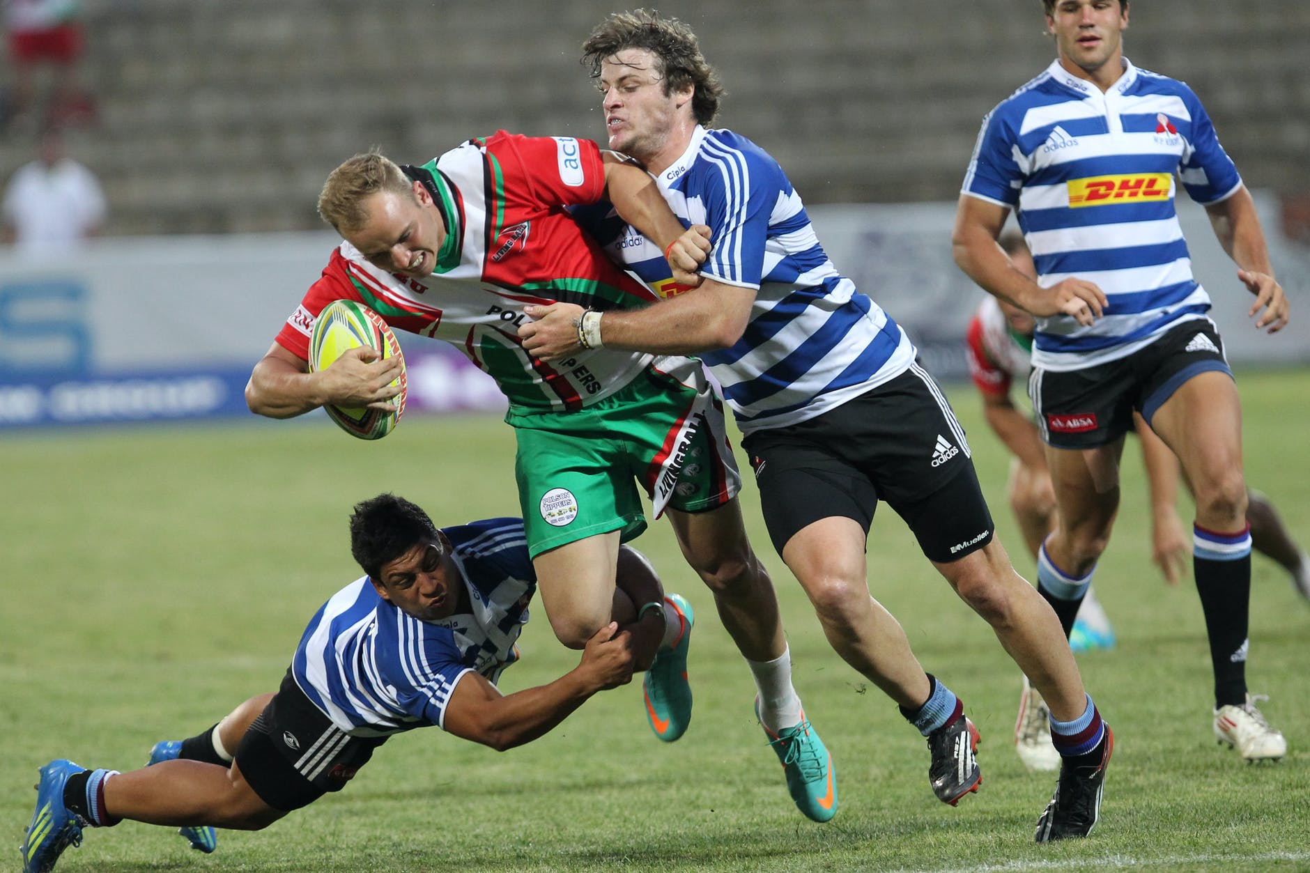 man in blue and white striped soccer jersey playing rugby